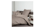 Mako-Satin Kissenbezug Colors, in der Größe 80 x 80 cm und in der Farbausführung beige, auf einem Bett bezogen mi der passenden Bettwäsche und weiteren Kissen