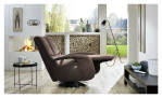 Komfort-Relaxsessel plano|FORM Swing Chair im Bezugsstoff Platin und einem Drehteller in Edelstahl. Auf einem dekorierten Hintergrund. Mit gezeigter Funktion.
