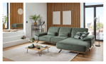 Komfort-Ecksofa plano|FORM Este in einem grünen Bezugsstoff und einem sichtrahmen in Wildeiche. Auf einem dekorierten Hintergrund.