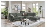 Komfort-Ecksofa MONDO Mimas in einem Stoffbezug in Moos. Auf einem dekorierten Hintergrund