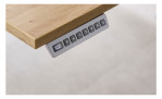 Elektro-Winkelschreibtisch mit holzfarbener Tischplatte und silbernem Gestell. Detailausschnitt Fernbedienung.