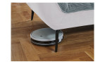 Detailfoto von der Höhe der Füße, mit einem Staubsaug-Roboter