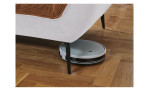 Detailfoto von der Höhe der Füße, mit einem Staubsaug-Roboter