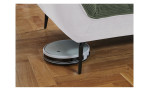 Detailfoto von der Höhe der Füße, mit einem Staubsaug-Roboter