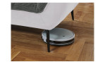 Detailfoto von der Höhe der Füße, mit einem Staubsaug-Roboter